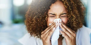 Woman blowing nose