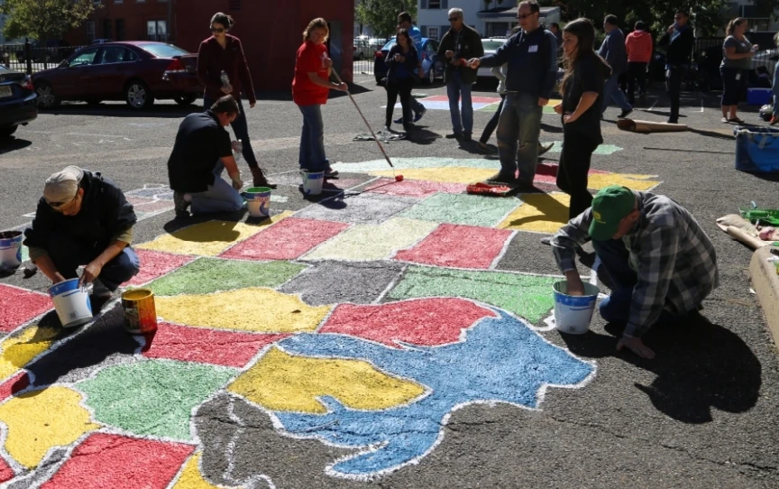 People painting a map of the US on a parking lot
