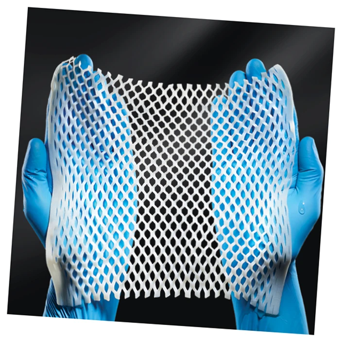 Gloved hands holding up an engineered collagen matrix