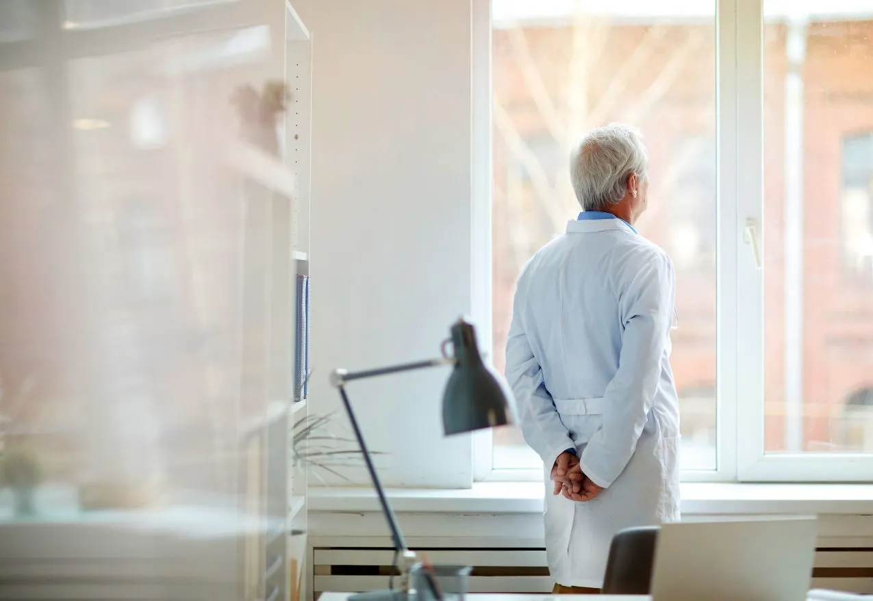 surgeon looking out the window in their office