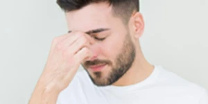 Man pinching nose bridge